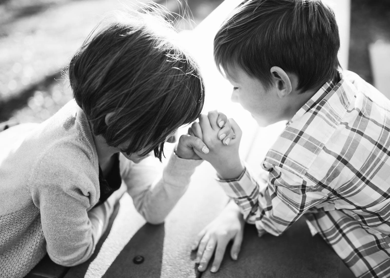 Shannon’s twins, face to face across a table, arm wrestling